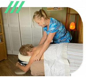 There Brown giving a massage to a woman laying on a bed